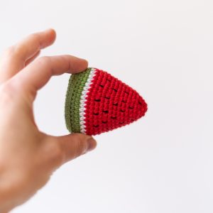 Zabawka dla kota arbuz z kocimiętką i walerianą trzymany w dłoni